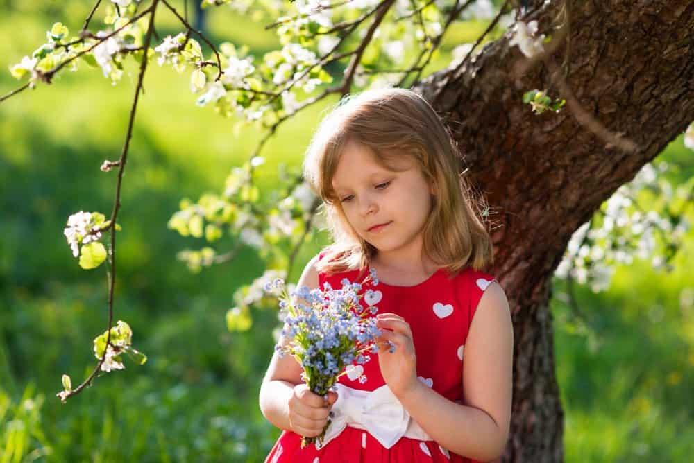Little girl looking at the bouquet of flowers in her hands