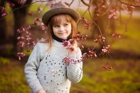 Cute little girl in a hat having fun in the park