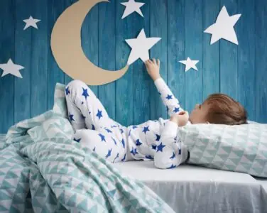 Little boy looking at the star on the wall of his bedroom