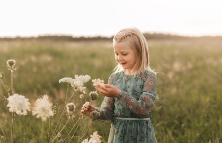 Little girl picking flowers in the field