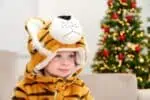 Little boy in a tiger costume sitting on the sofa