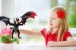 Little girl playing with a toy dragon