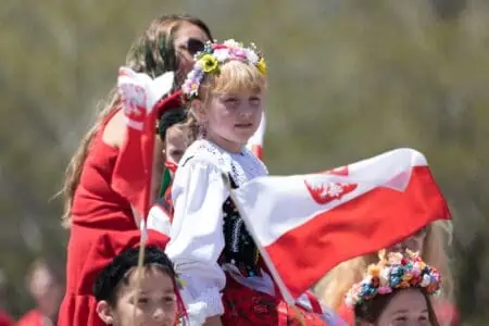 Little Polish girl in traditional dress celebrating the Polish Constitution Day.