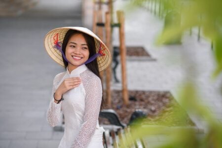 Vietnamese girl in Ao Dai dress spending time outdoors