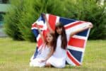 Two happy girls holding flag of the United Kingdom.