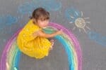 Little girl drawing a rainbow.