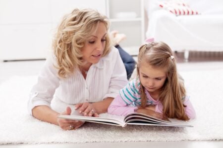 Mother reading a book to her daughter.