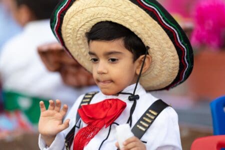 Little Mexican boy in sombrero having fun during the Mexican Revolution Day Parade.