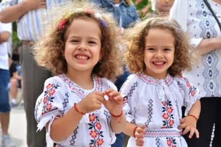 Two girls dressed in traditional Romanian costumes having fun during the festival.