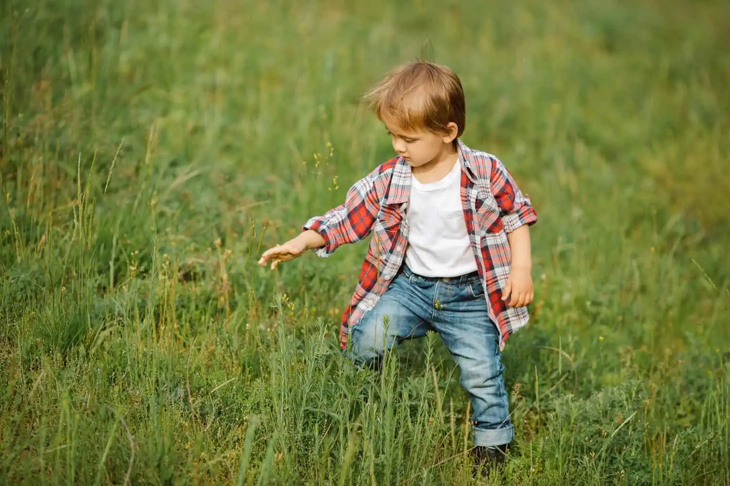 Happy little boy playing outdoor on the nature