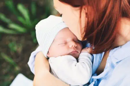 Mother kissing her newborn baby.