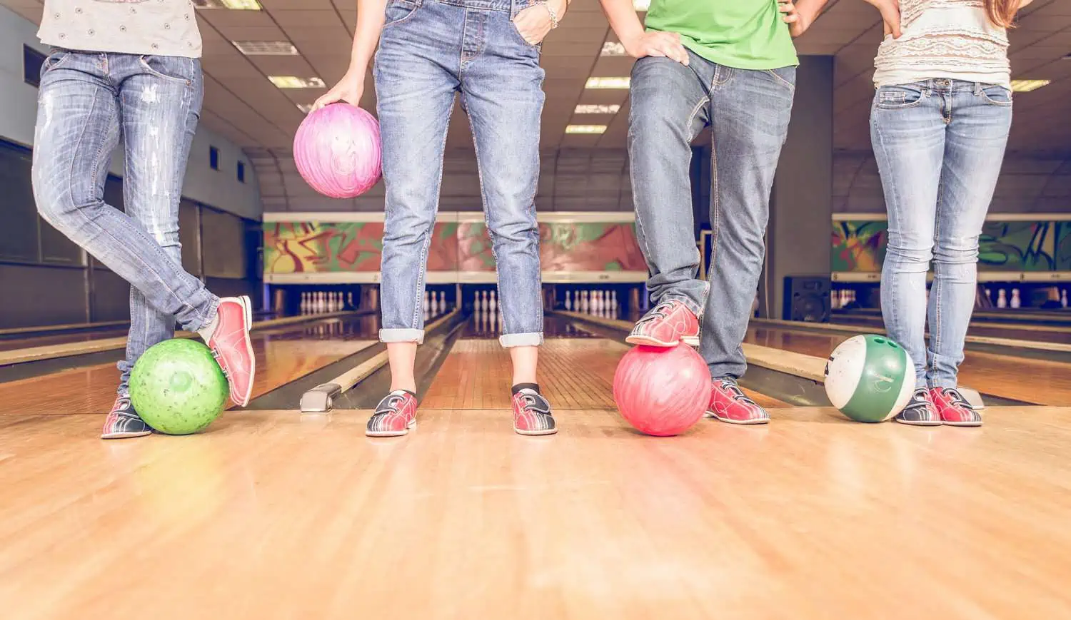 Four people with bowling balls