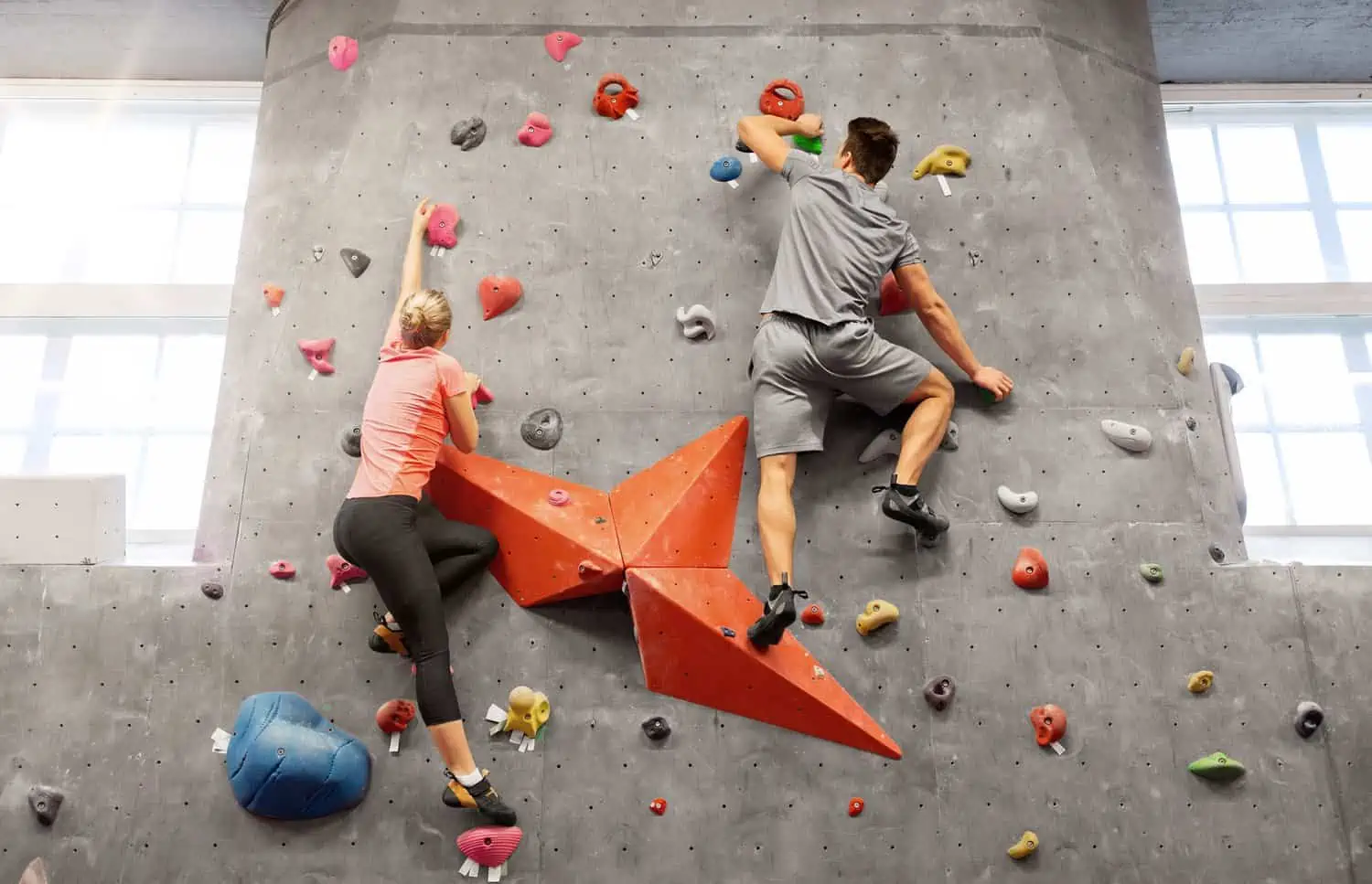 Man and woman climbing wall at indoor gym