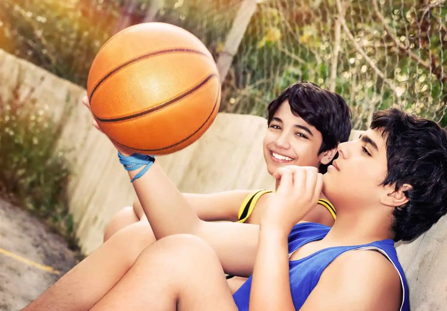 Two happy basketball players sitting and resting
