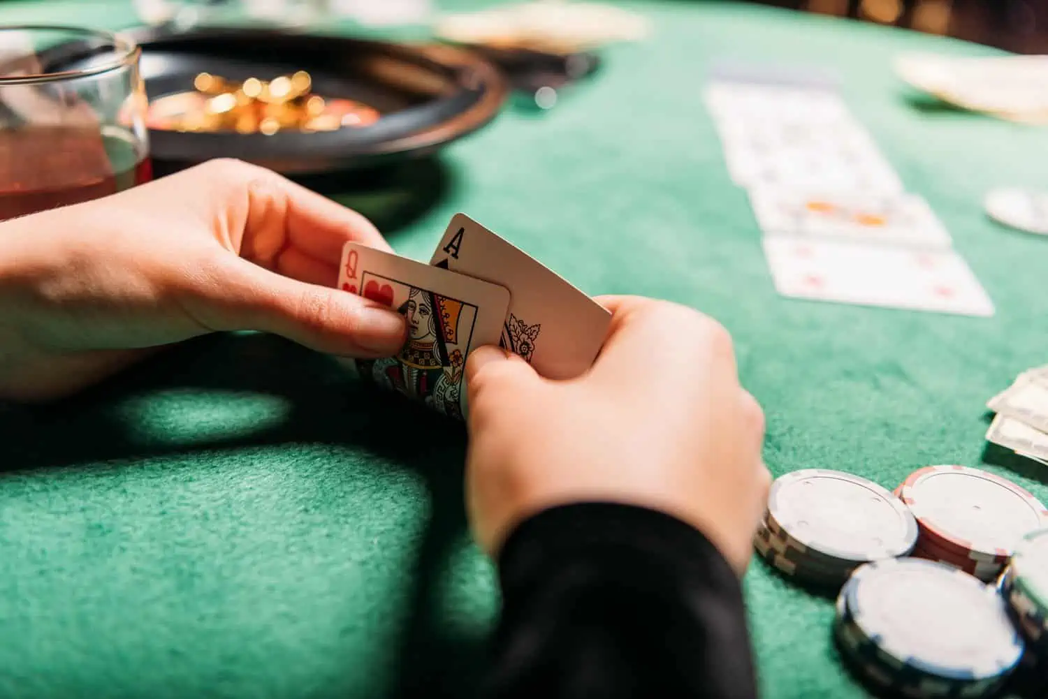 Player holding ace and queen cards at poker game