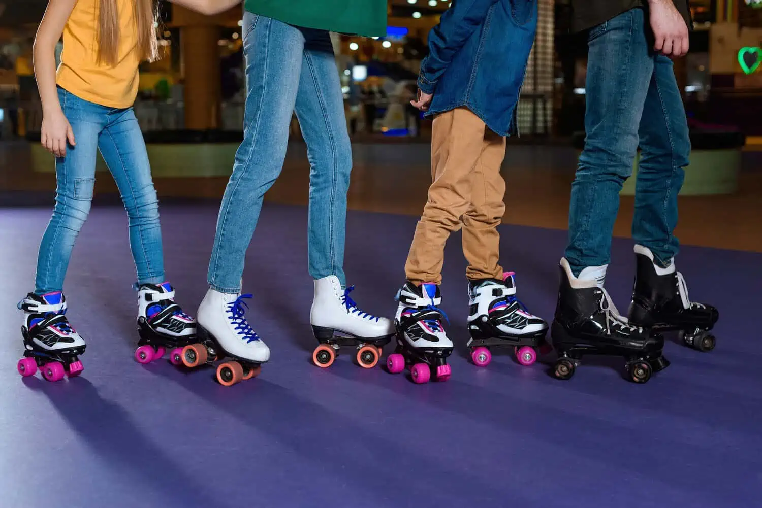 Partial view of parents and kids skating on roller rink together