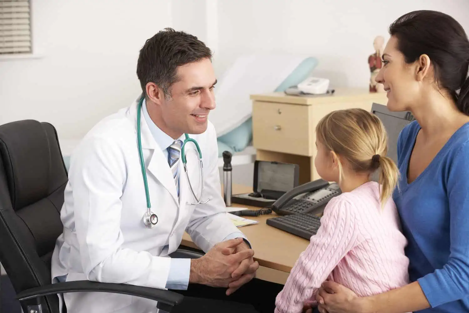 Doctor talking to young child and mother in the clinic