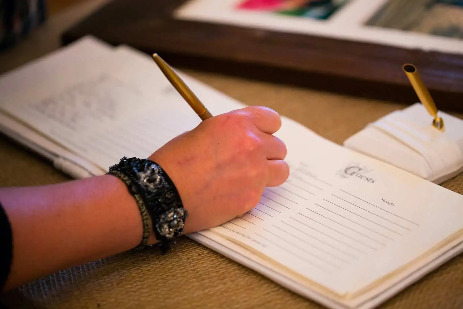 Person signing the guestbook at the wedding reception