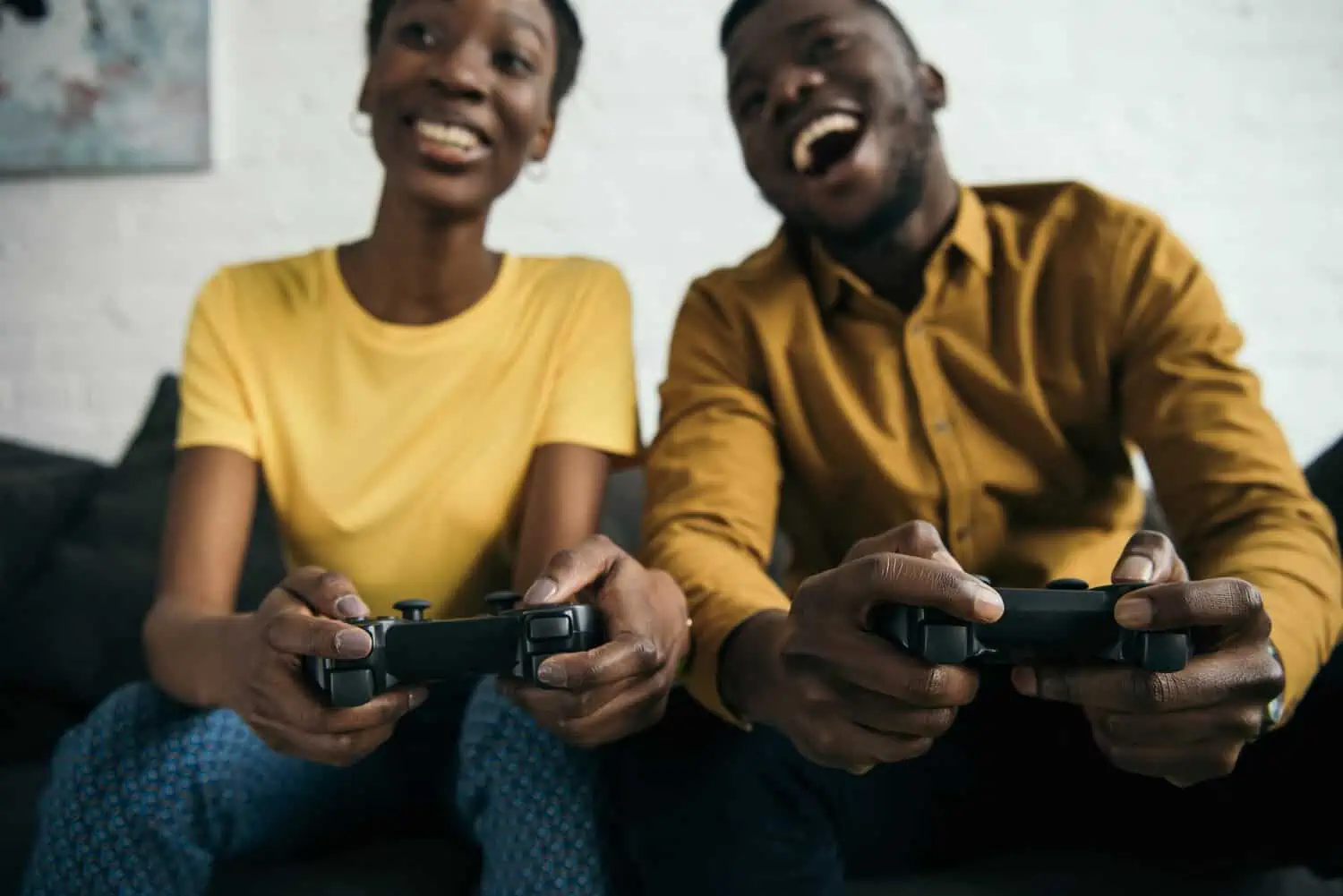 Two young adult in yellow playing video games