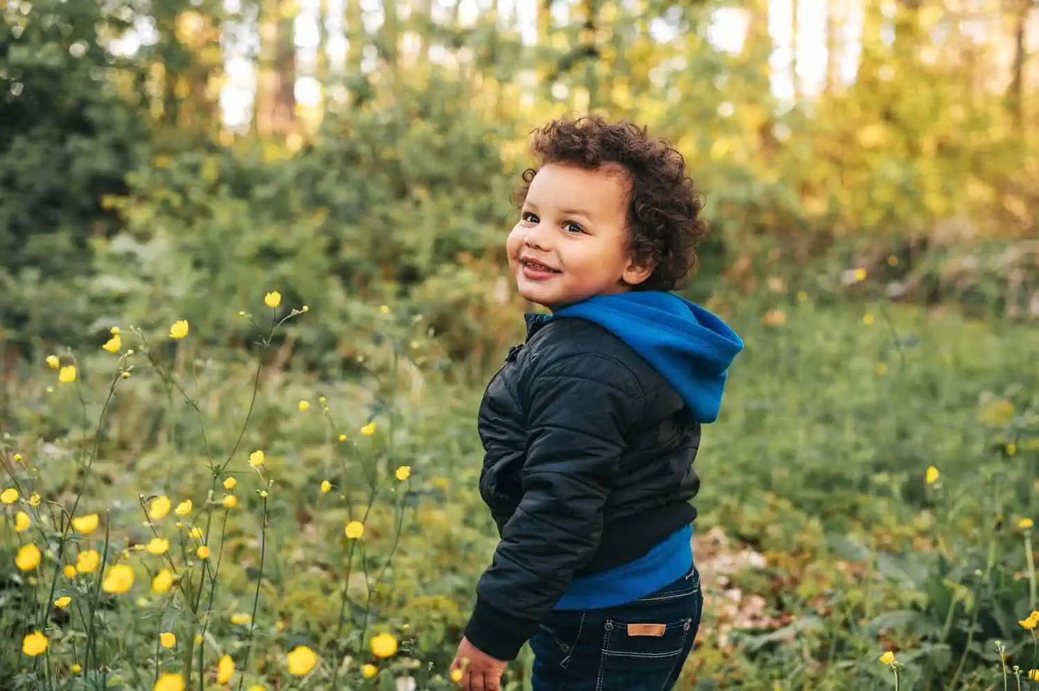 Adorable african toddler boy hiking in spring forest