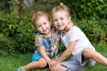 Two adorable brothers hugging outdoors