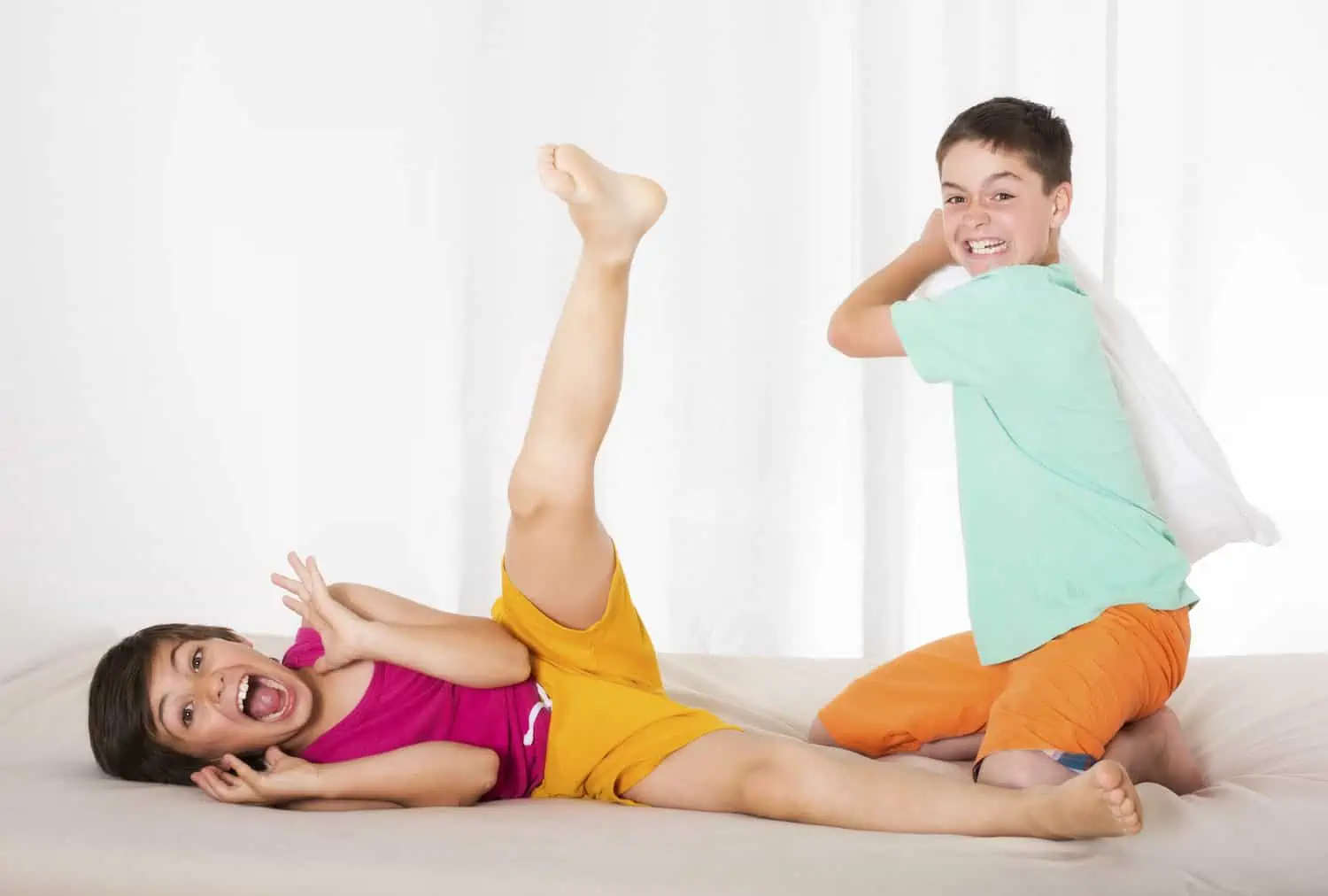 Two boys having pillow fight and laughing