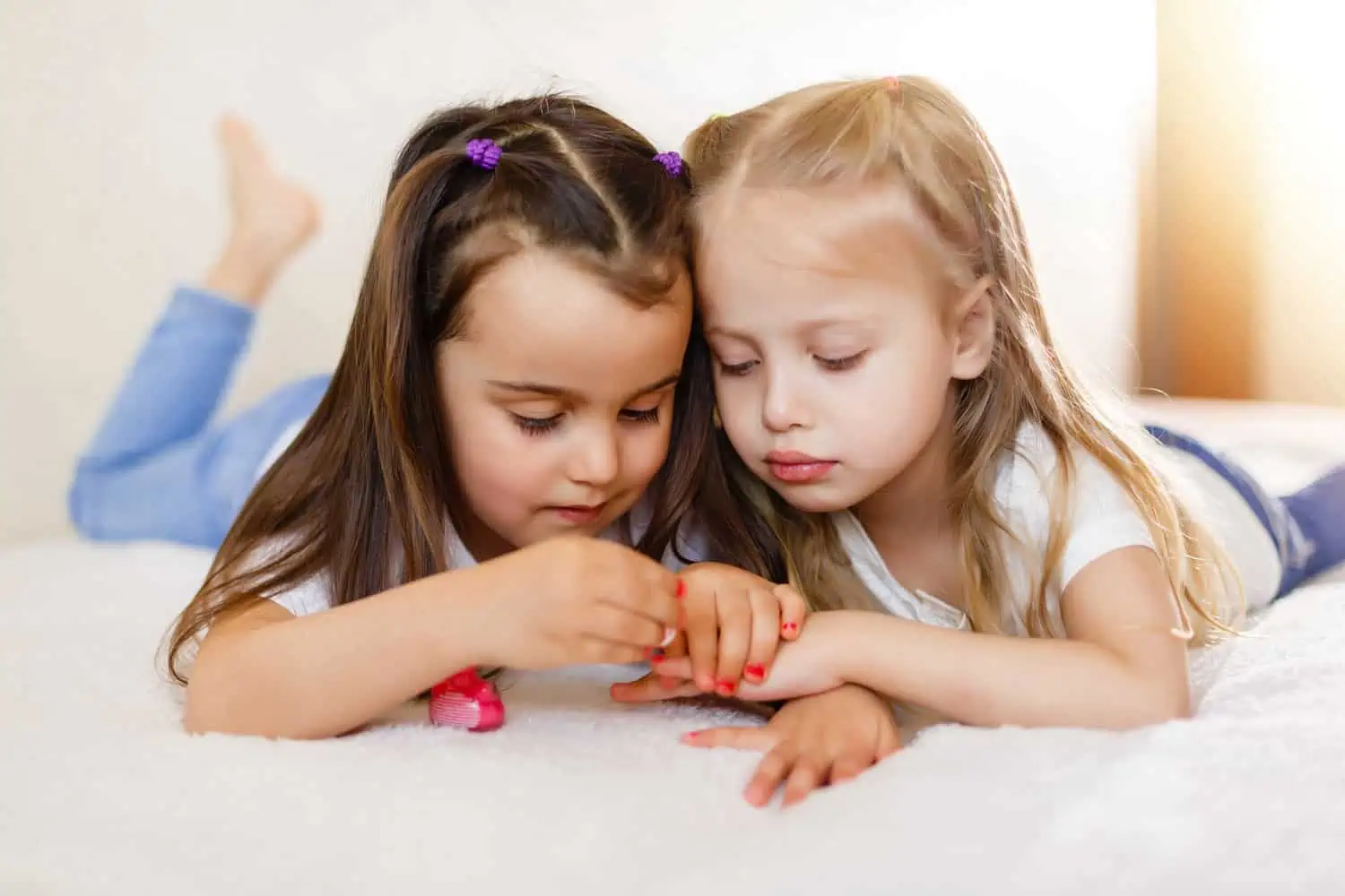 Two little girls painting their nails at home