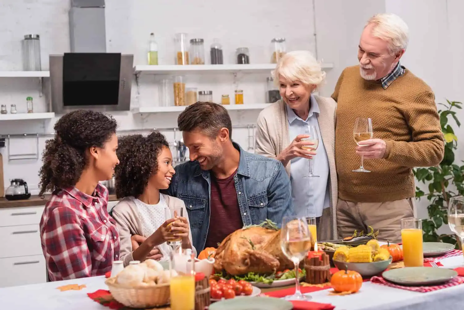 Mixed-race family happily having thanksgiving dinner together