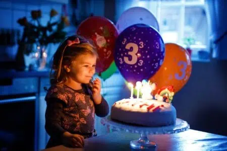 Cute toddler girl celebrating third birthday
