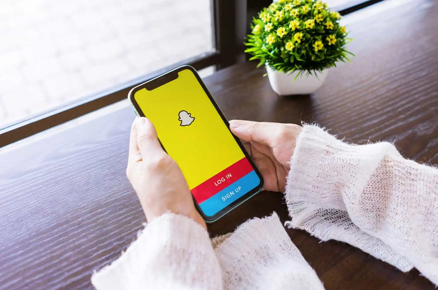 Woman holding smartphone with snapchat logo on screen