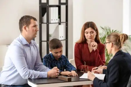 Parents with their son consulting lawyer in the office