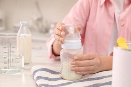 Mother preparing infant formula at the table
