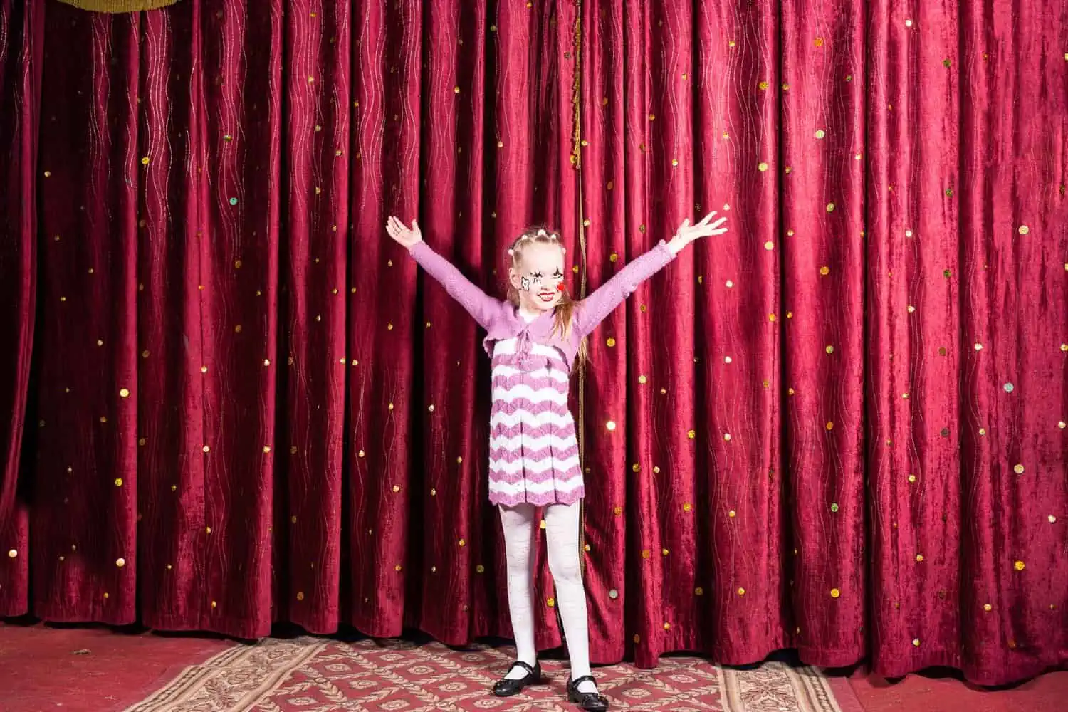 Little girl standing on stage during performance