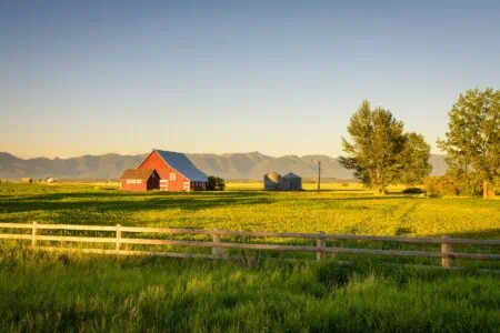 Peaceful ranch with a red barn during sunrise