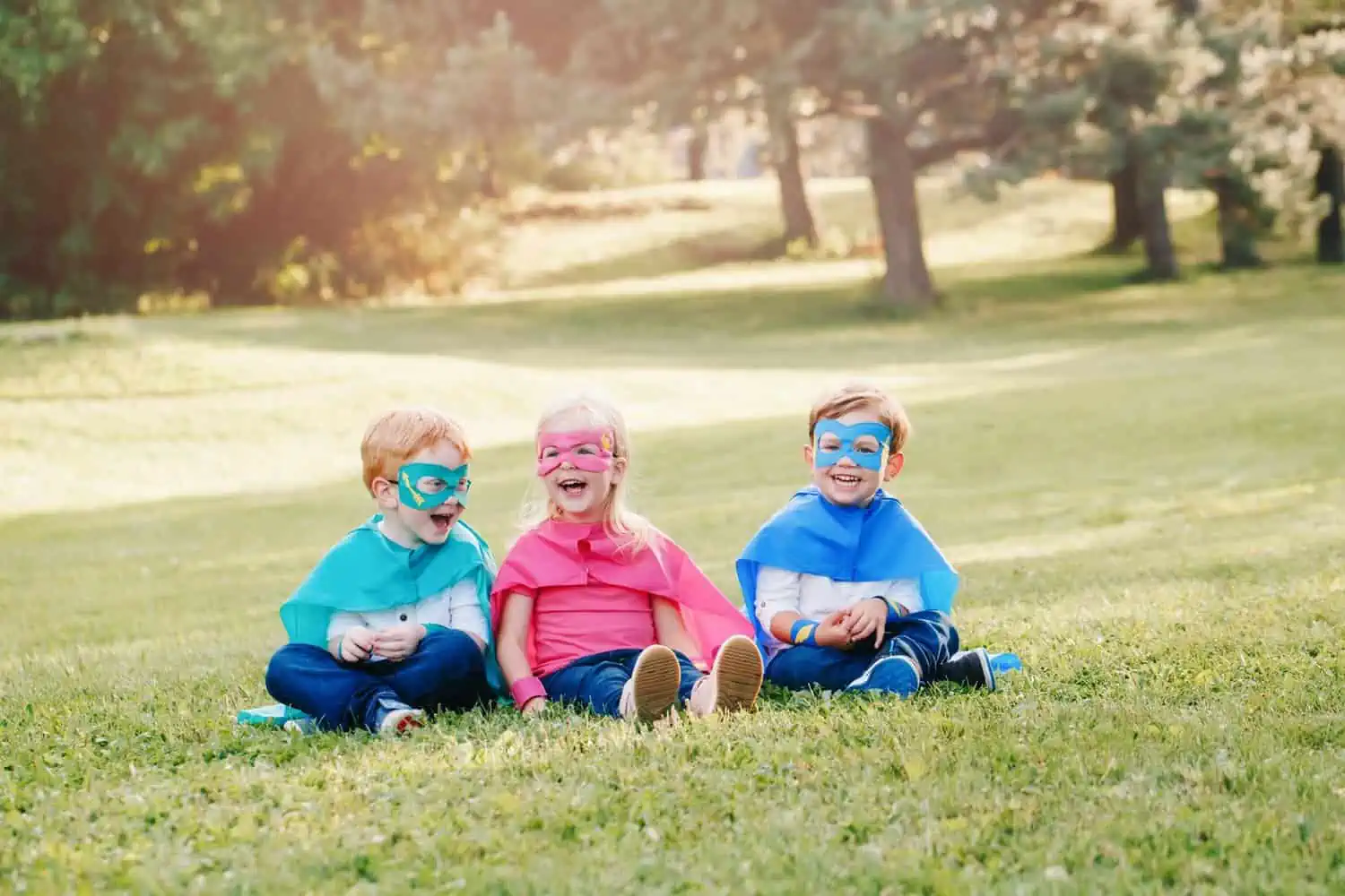 Adorable preschool children playing superheroes in the park