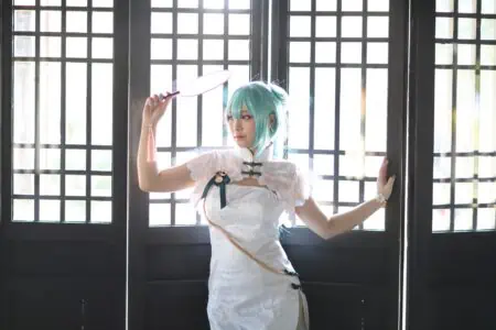 Girl wearing anime cosplay costume standing against traditional window