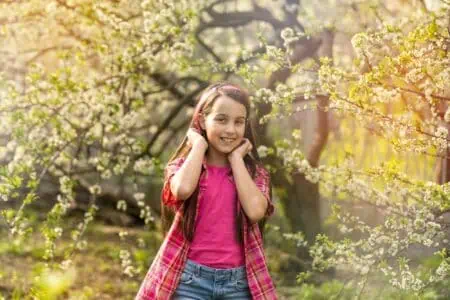 Cheerful young girl standing in spring park