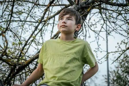 Young boy wearing light green shirt against nature background